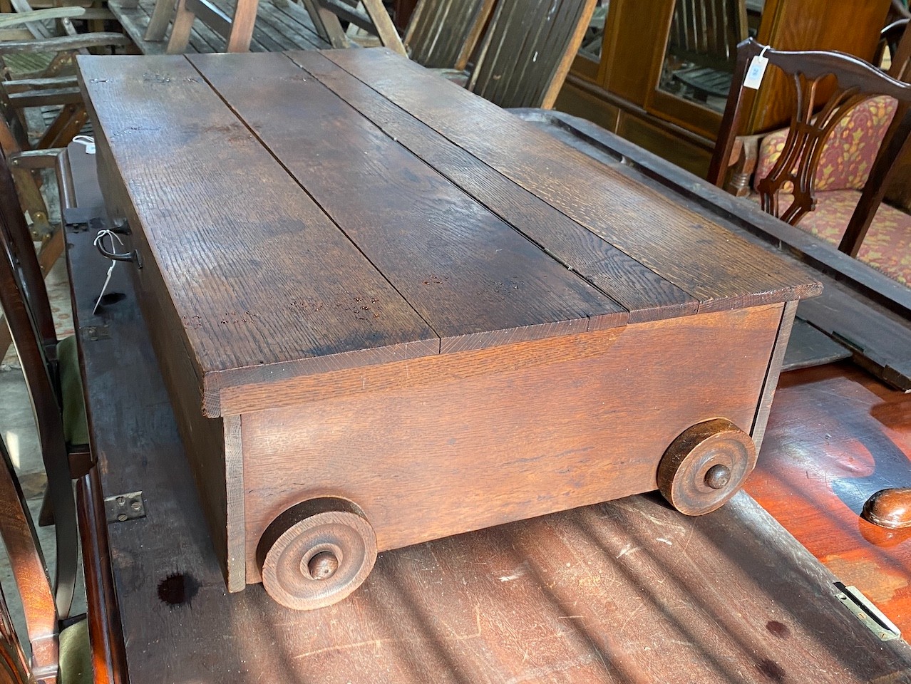 An oak under-bed storage box on wheels, length 123cm, depth 62cm, height 26cm